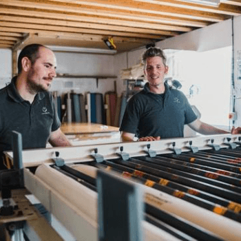 Ian and Jamie lining up a mattress in the press ready for hand tufting