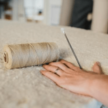Top cotton layer of mattress being hand side stitched with flax thread